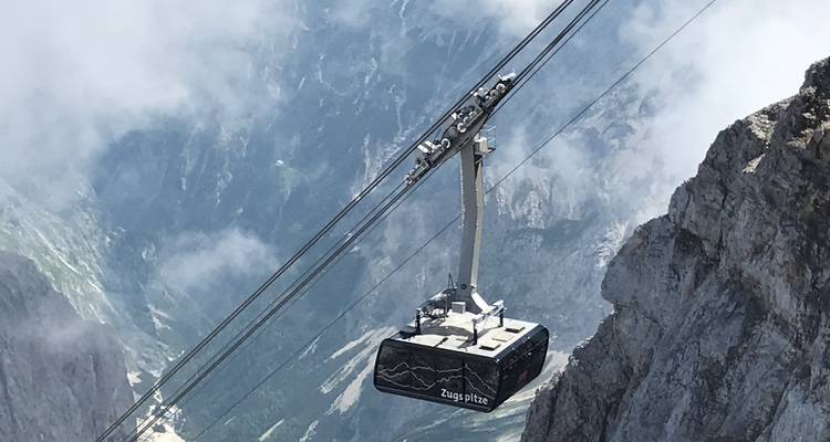 Téléphérique montant dans un paysage de montagne enneigée.
