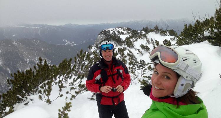 Groupe de personnes en équipement de ski sur une montagne enneigée.