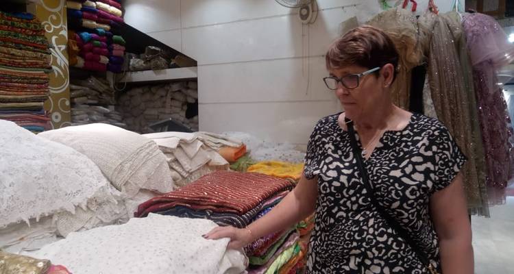 Frau betrachtet Textilien in einem Stoffgeschäft.