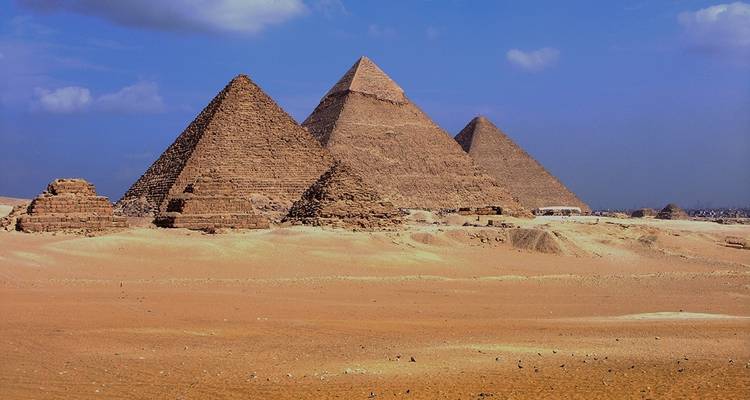The Pyramids of Giza under a blue sky.