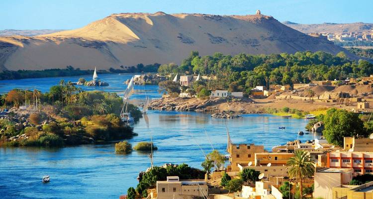 The Nile River with sailboats and desert landscape.
