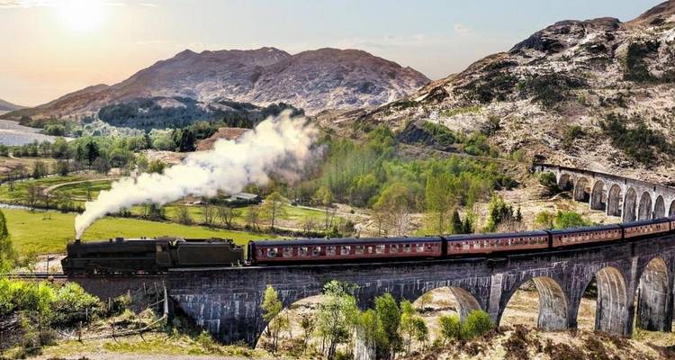 Un train à vapeur traverse le viaduc de Glenfinnan en Écosse.