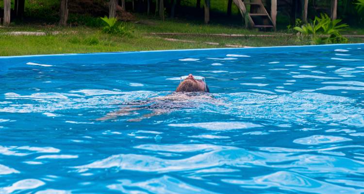 Person, die in einem Schwimmbecken treibt.