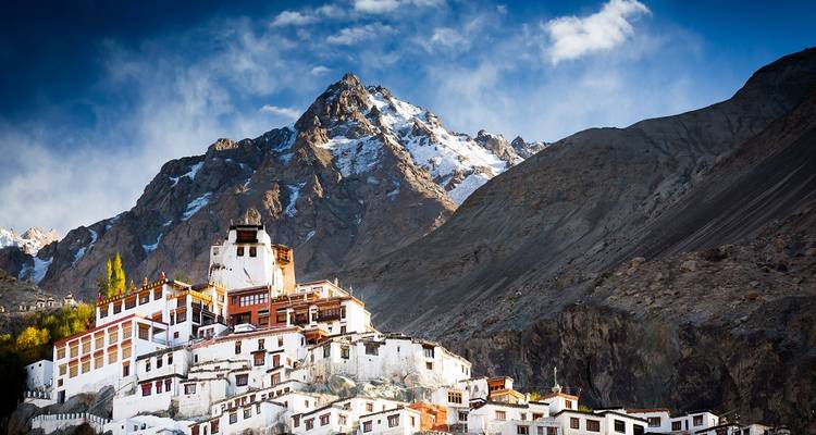 Un monastère adossé à des montagnes escarpées enneigées.