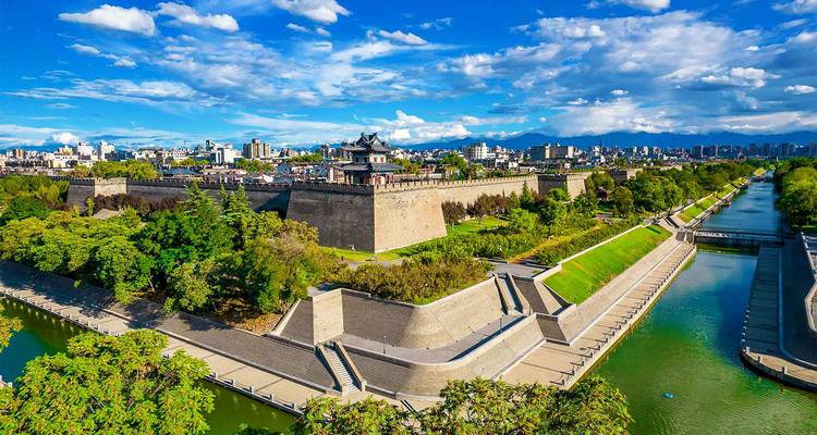 Vue panoramique de la muraille de Xi'an et de ses douves avec l'horizon urbain et les montagnes en arrière-plan