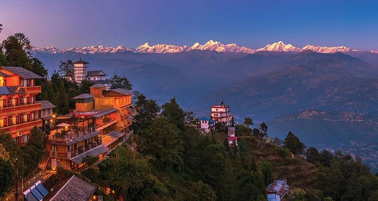 Scenic view of mountains with lit buildings in the foreground.