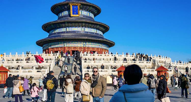 Crowds gather on the stone terrace below Beijing’s circular, blue-tiled Temple of Heaven on a clear winter day.