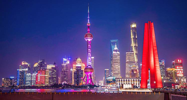 Colorful neon lights illuminate Shanghai’s iconic Pudong skyline featuring the Oriental Pearl Tower and soaring skyscrapers.