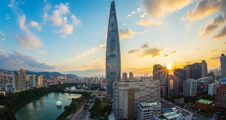 Torre Lotte World en Seúl durante el atardecer con el paisaje urbano de fondo.