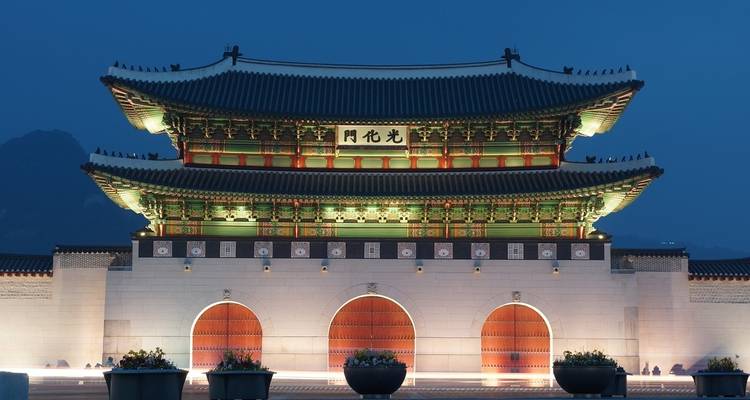 Palacio Gyeongbokgung por la noche, bien iluminado mostrando su intrincada arquitectura.