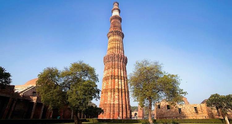 Qutub Minar, a large historic tower surrounded by greenery.