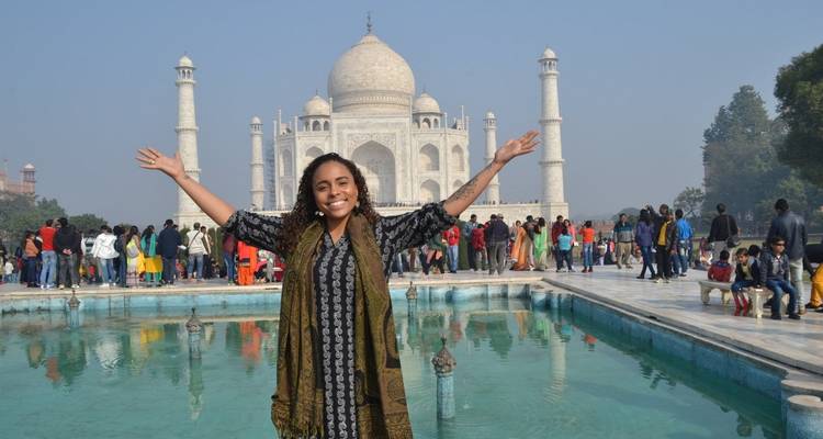 Touriste posant devant le Taj Mahal avec une grande foule.