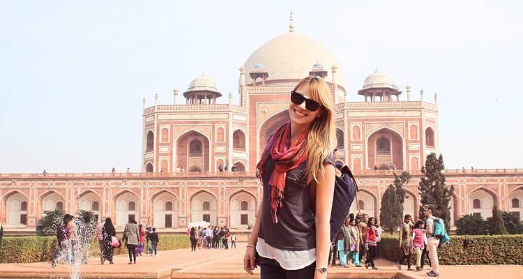 A tourist smiling in front of Humayun's Tomb.