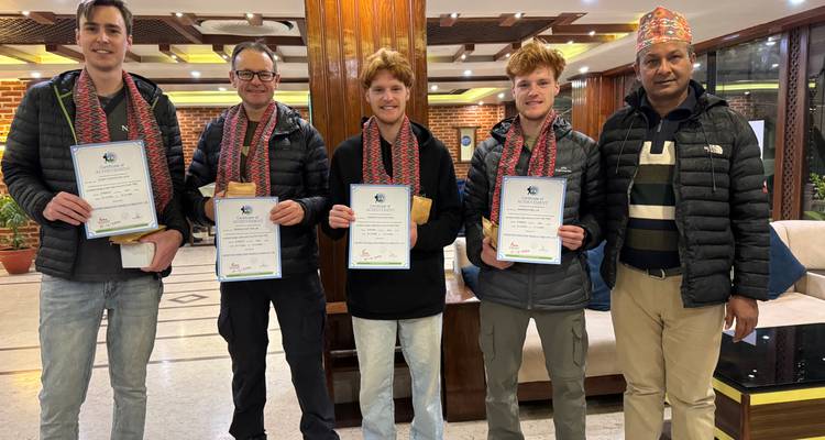 Groupe de personnes à l'intérieur posant avec des certificats.