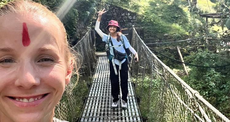 Deux personnes sur un pont suspendu dans un cadre luxuriant.