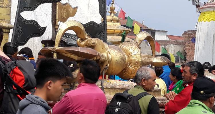 Menigte die rond een groot verguld ritueel donderbouten (vajra) op een stupa-binnenplaats staat