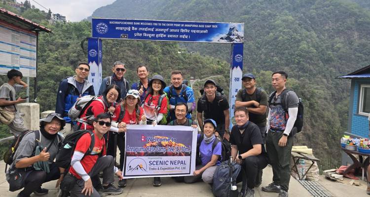 Le groupe de trekking pose sous une arche de bienvenue sur le sentier de l'Annapurna.