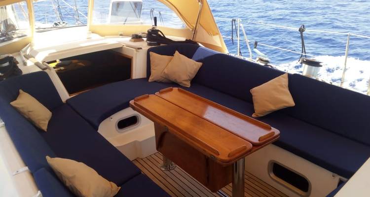 Interior de un yate con asientos y una mesa de madera.