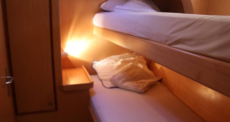 Interior of a boat cabin with bunk beds.