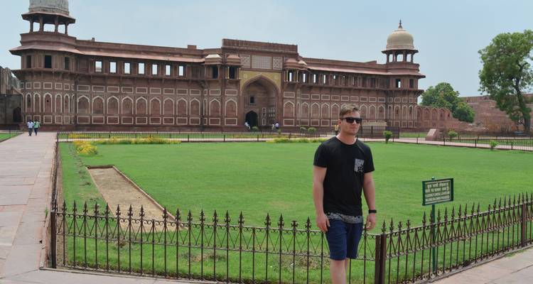 Toerist die voor een groot historisch gebouw staat.