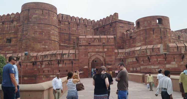 Mensen die naar de ingang van een historisch fort lopen.