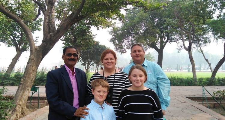 Familienfoto in einer Gartenlandschaft mit Bäumen.