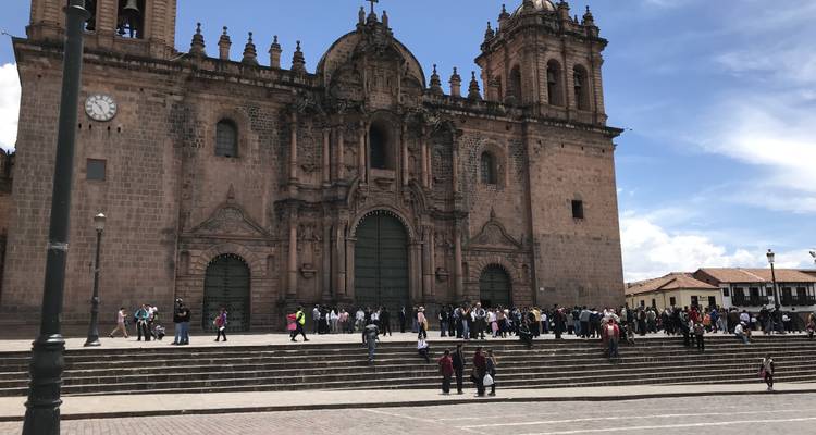 Ein kunstvolles historisches Gebäude mit großen Stufen und einer Menschenmenge.