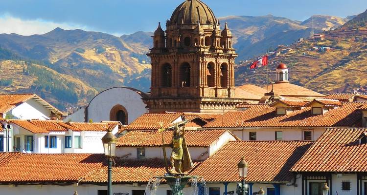 Clocher colonial et toits de Cusco avec les montagnes andines qui s'élèvent derrière