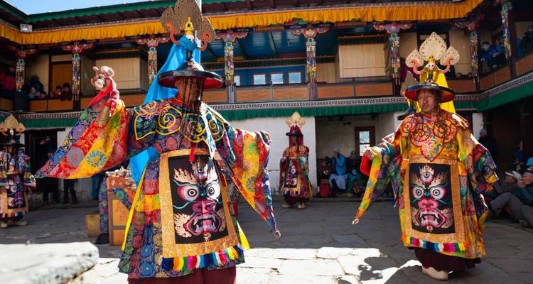 Künstler in leuchtenden Kostümen tanzen während eines Festivals.