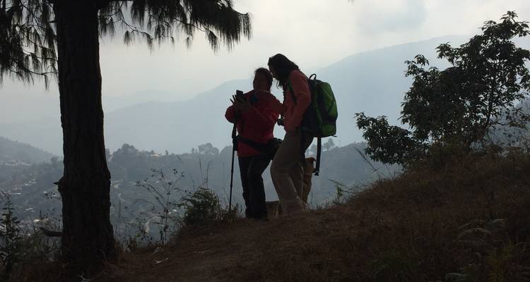 Zwei Wanderer auf einem Bergpfad mit nebligem Hintergrund.