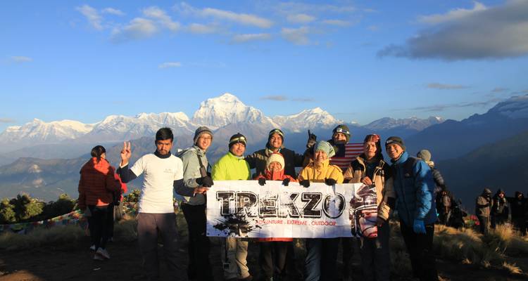 Groupe de personnes tenant une bannière avec des montagnes en arrière-plan.