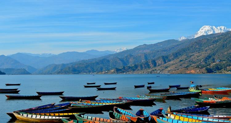 Boten op een meer met bergen op de achtergrond.