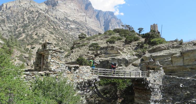 Een stenen brug in een berglandschap.