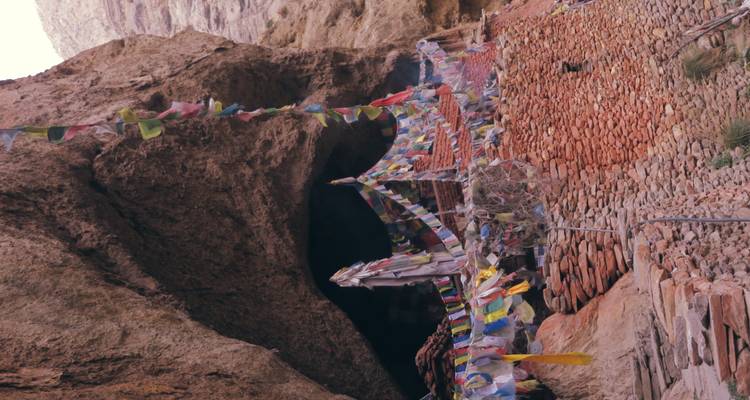 Kleurrijke gebedsvlaggen die hangen in een rotsachtig berggebied.