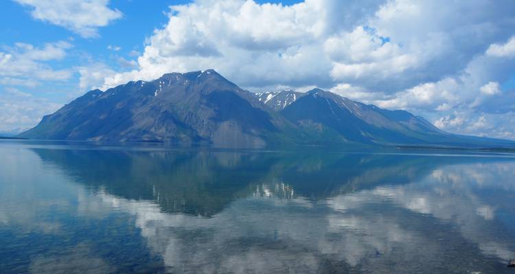 Stunning reflection of mountains in a calm lake under a blue sky.