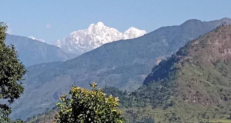 Mountain range in the distance with clear skies and vegetation in the foreground.