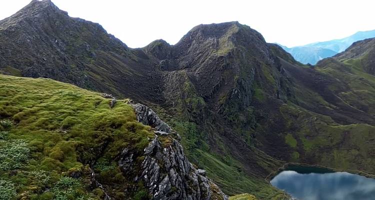 Aerial view of rugged mountains and a small lake.