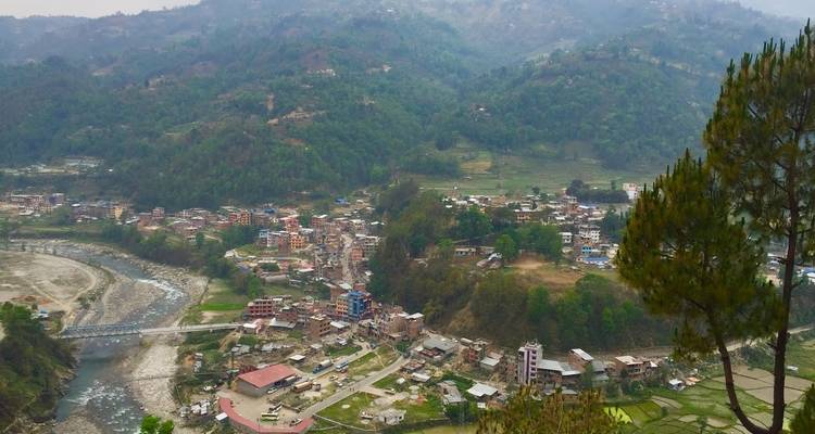 View of a village with houses nestled in green hills.