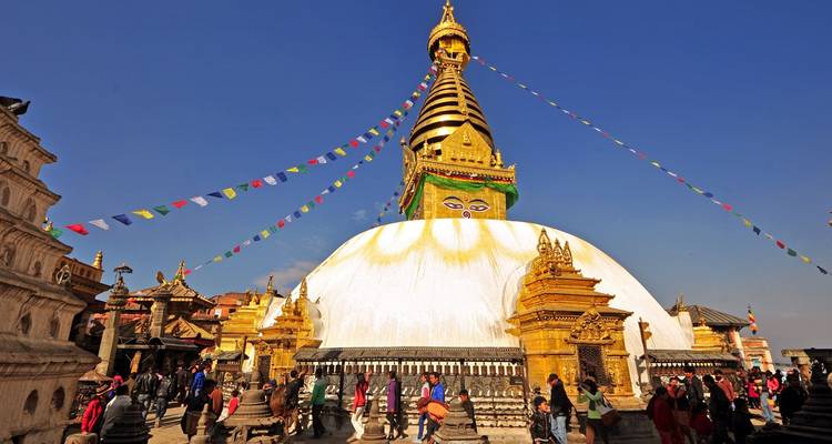Swayambhunath-Stupa in Kathmandu mit blauem Himmel und bunten Gebetsfahnen.