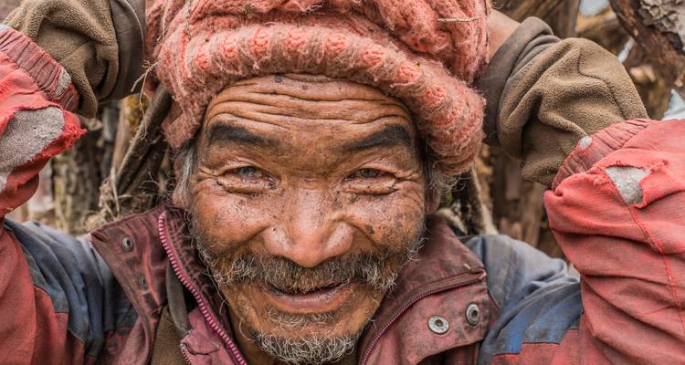 Nahaufnahme eines lächelnden älteren Mannes mit rustikalem Aussehen.
