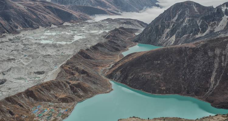 Kristallblauer Gletschersee umgeben von dramatischen Berggipfeln.