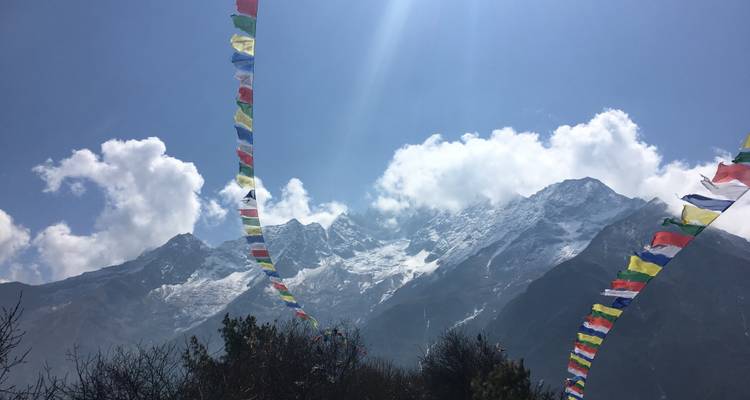 Mountains with prayer flags under a clear sky.