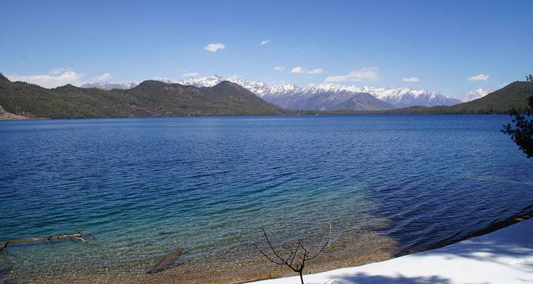 See mit verschneiten Bergen im Hintergrund