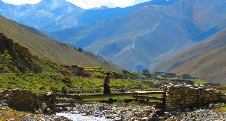 Person, die eine Holzbrücke in einer Bergregion überquert