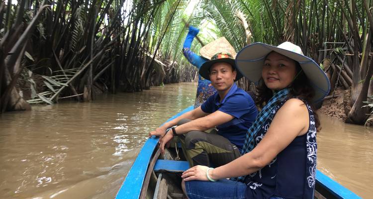 Menschen auf einem Boot, das durch einen engen Kanal fährt.