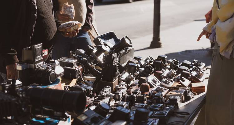 Street market stall displaying a variety of vintage cameras.