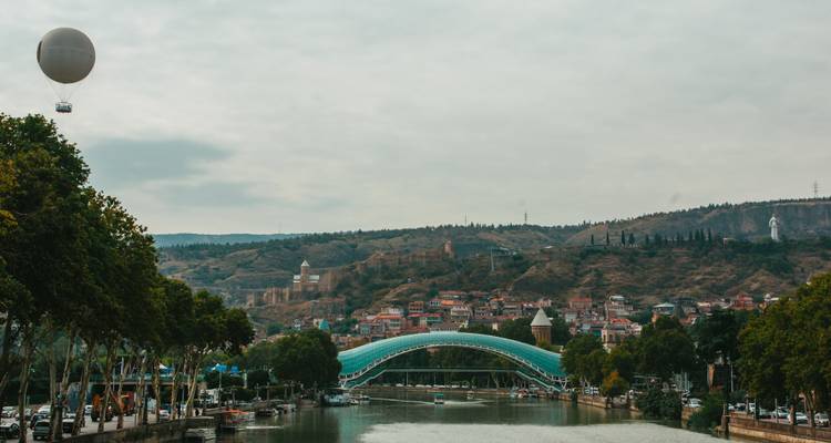 Bridge of Peace over a river with a hot air balloon in the sky.