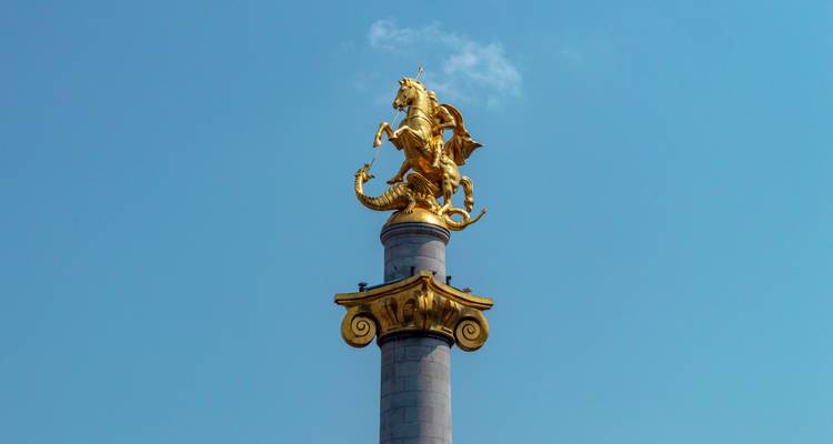 Golden statue of Saint George slaying a dragon on a column.