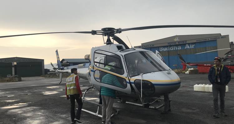 People preparing to board a helicopter at a small airport.
