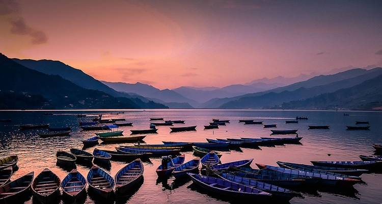Bateaux flottant sur un lac serein au coucher du soleil.